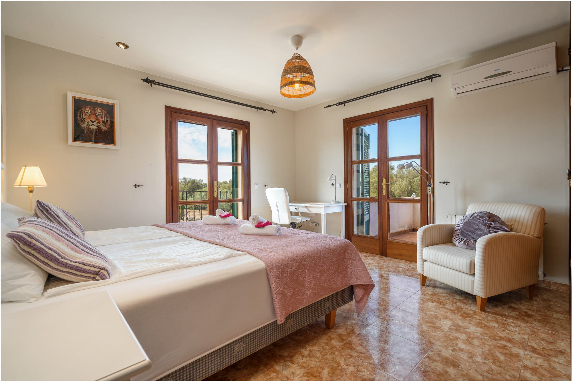Aslan bedroom with a desk, armchair and French doors